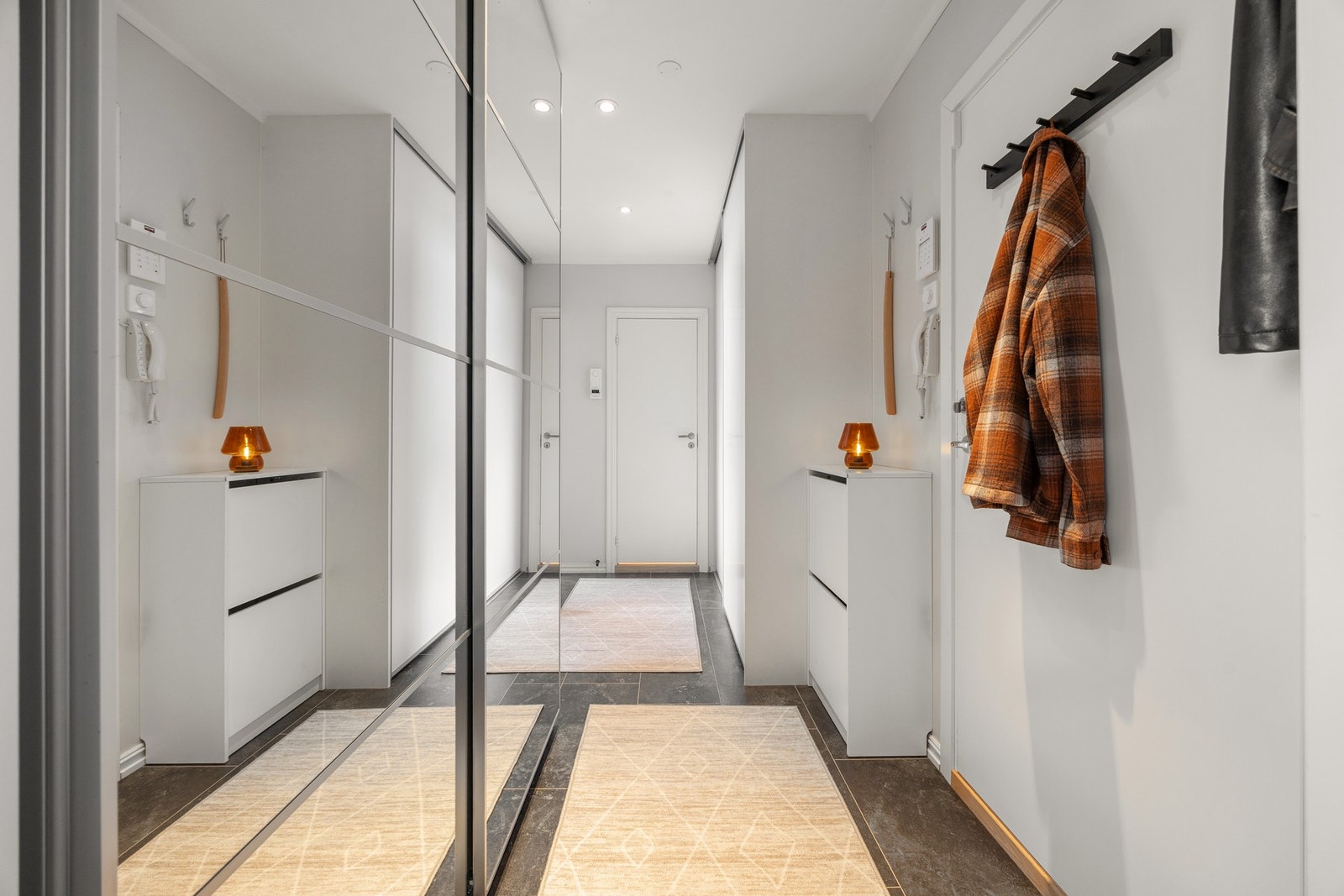 Tiltalende entré/gang med lysmalte veggflater og flisimitert laminat på gulv som gir et godt førsteinntrykk. Galleribilde