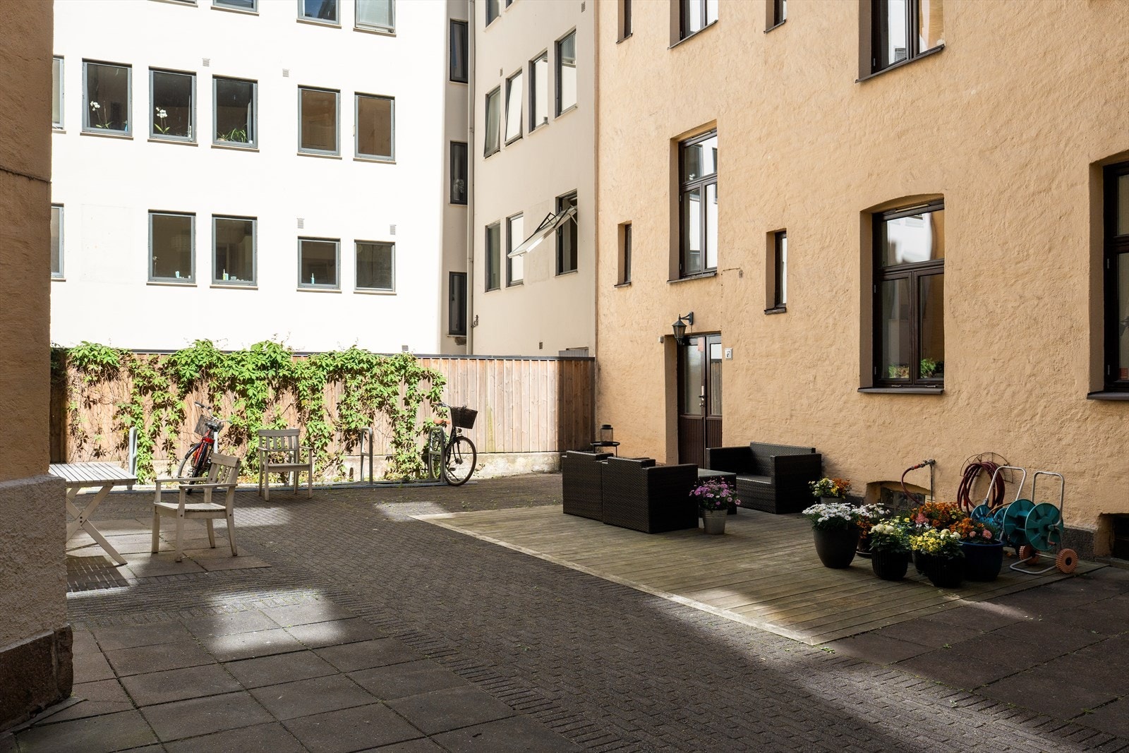Bakgården er opparbeidet med flere sittegrupper, gode oppholdsplasser og sykkelparkering. Galleribilde