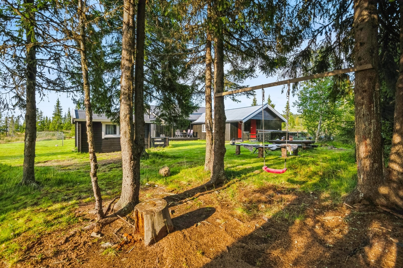 Eiendommen tilbyr et skjermet og rolig uteområde med lekeplass og naturlig vegetasjon. Galleribilde