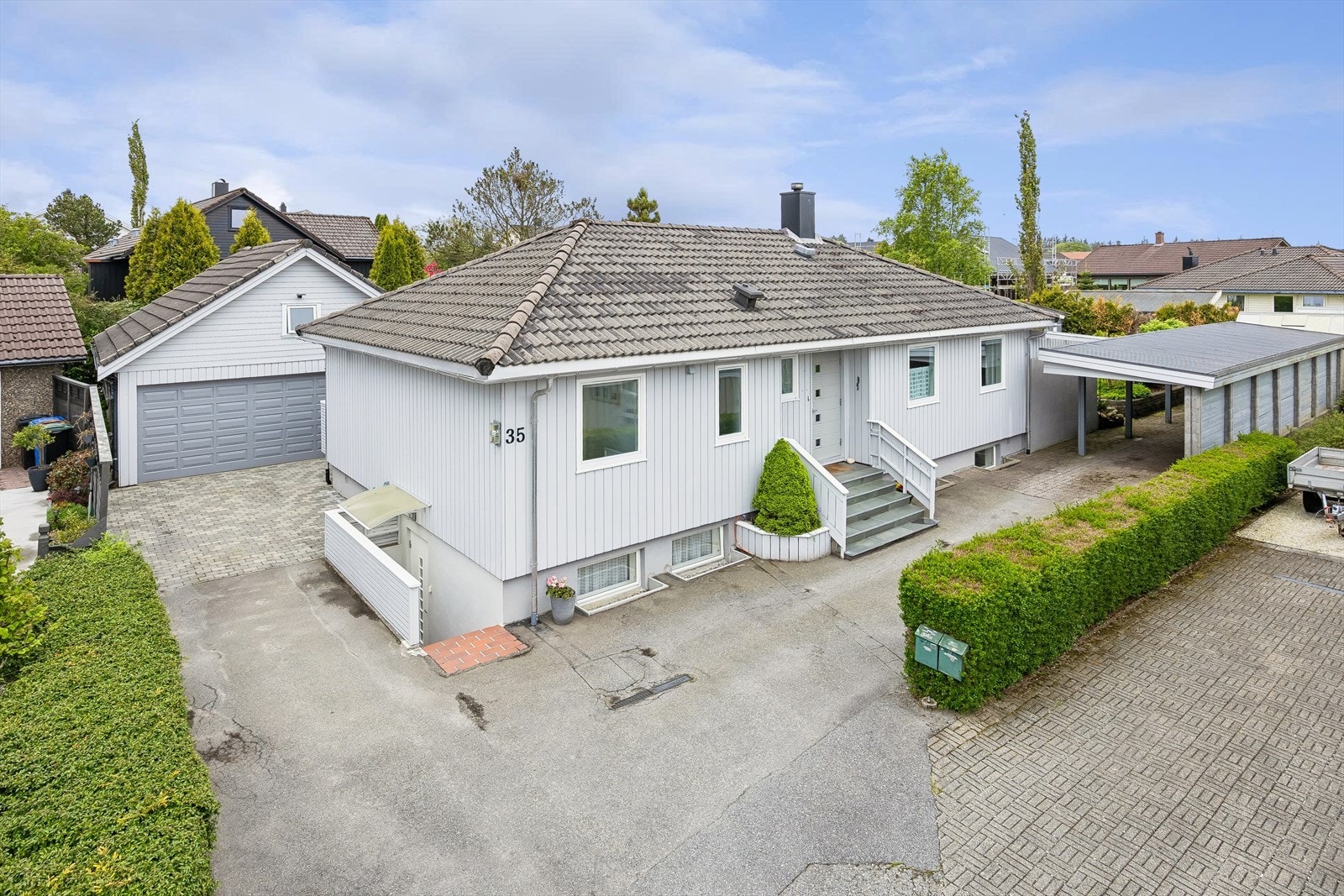 Parkering er enkelt i eget gårdsrom med plass til flere biler, i tillegg til både carport og dobbelgarasje. Galleribilde