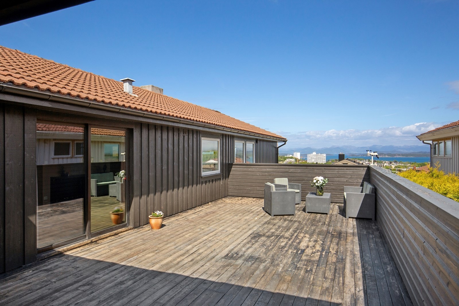 En stor terrasse på cirka 58 m² utvider boligens sosiale sone utendørs. Galleribilde