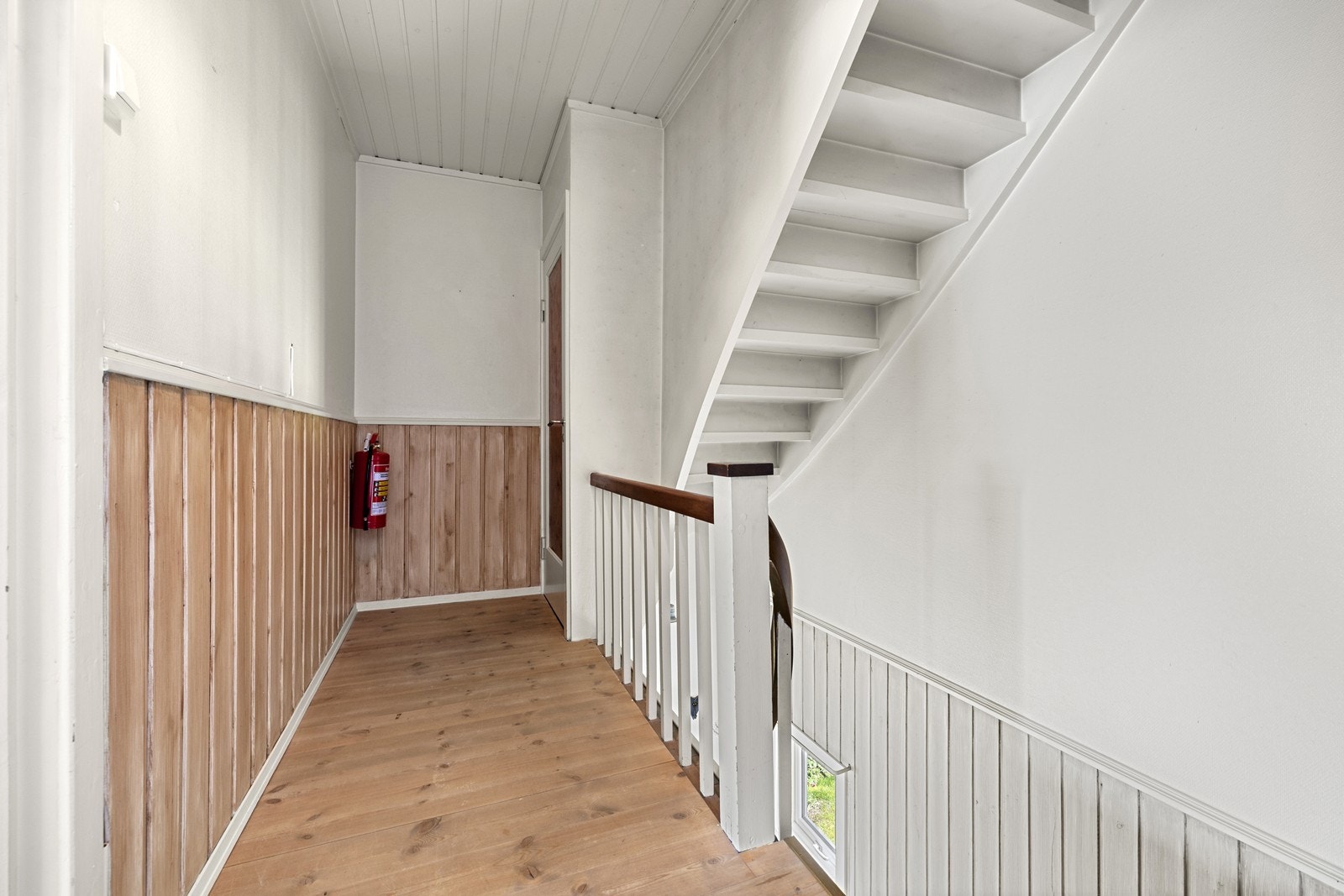 En malt furutrapp leder opp til andre etasje og videre til loftet. Galleribilde