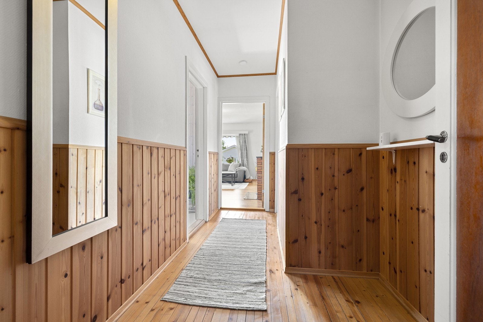 Gangen binder sammen rommene og har furugulv og panel på deler av veggen. Galleribilde