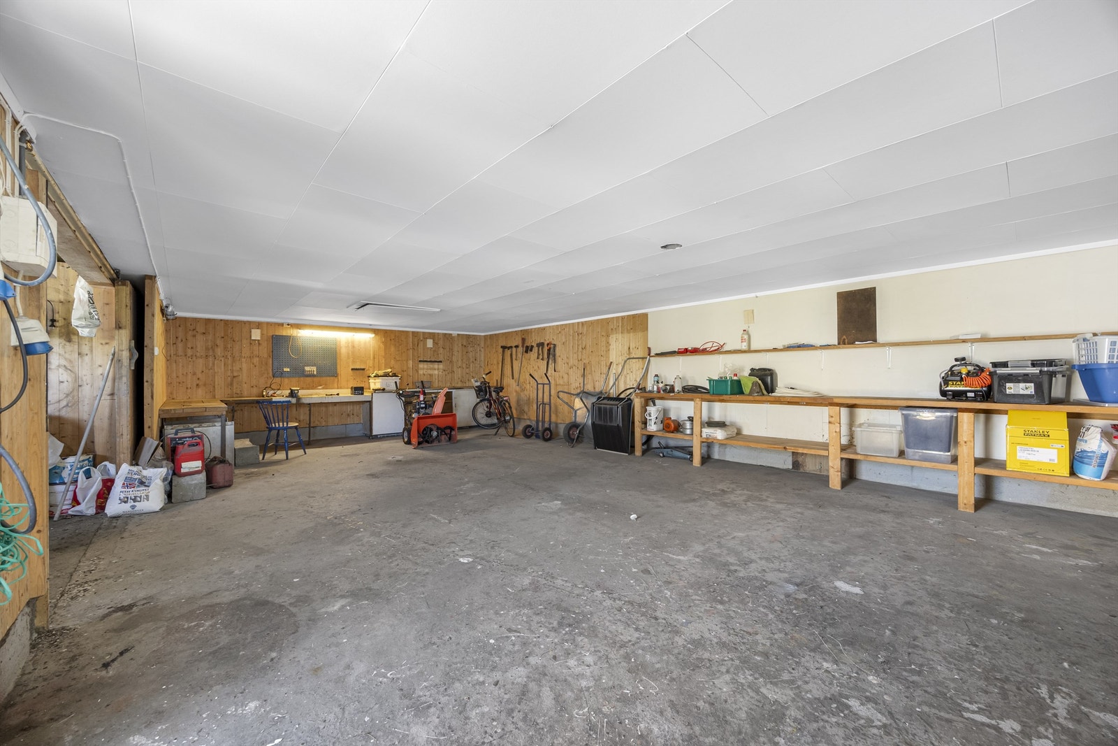 Den store garasjen gir rikelig med plass til både parkering, verksted og lagring av utstyr. Galleribilde