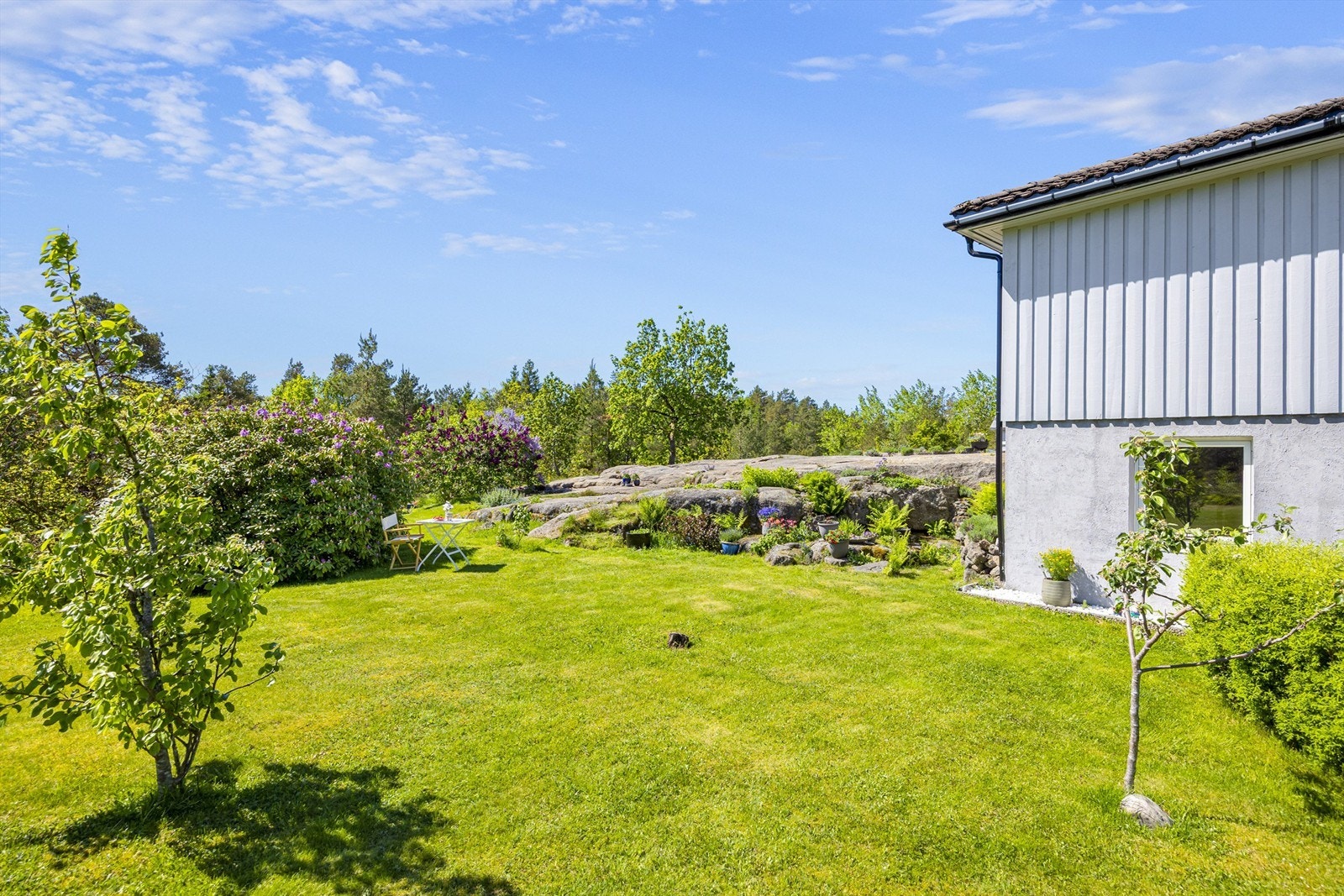 Tomten består av en kombinasjon av opparbeidet hage og naturtomt med svaberg. Galleribilde