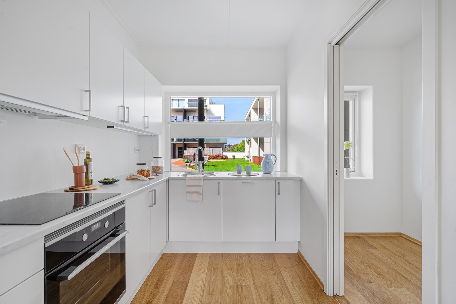 Kjøkkenet har rikelig med skap- og benkeplass og skyvedør inn til det ene soverommet. Galleribilde