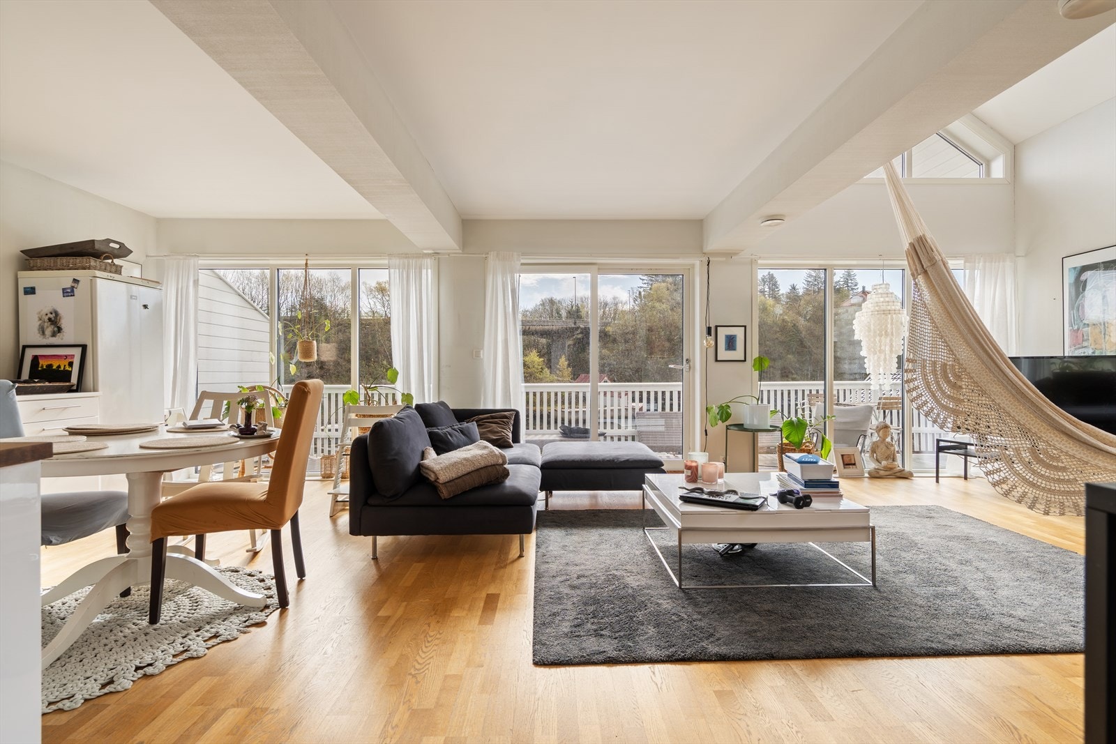 Lys og innbydende stue med store vindusflater og utgang til terrasse Galleribilde