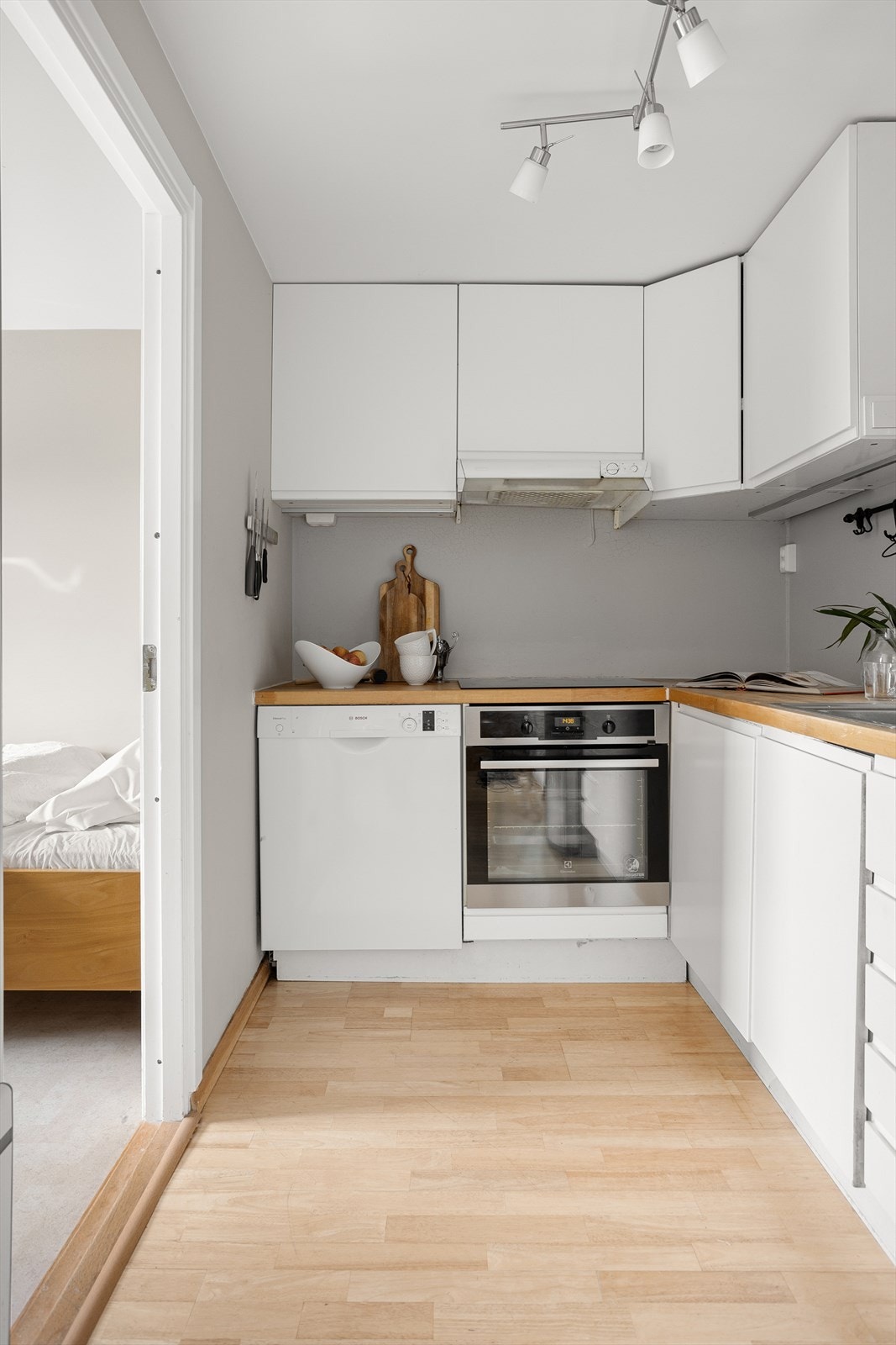 Laminat glatt kjøkkeninnredning som er eldre. Innredningen består av heltre benkeplate, ventilator vifte, nedfelt kum, integrert komfyr og platetopp. Galleribilde