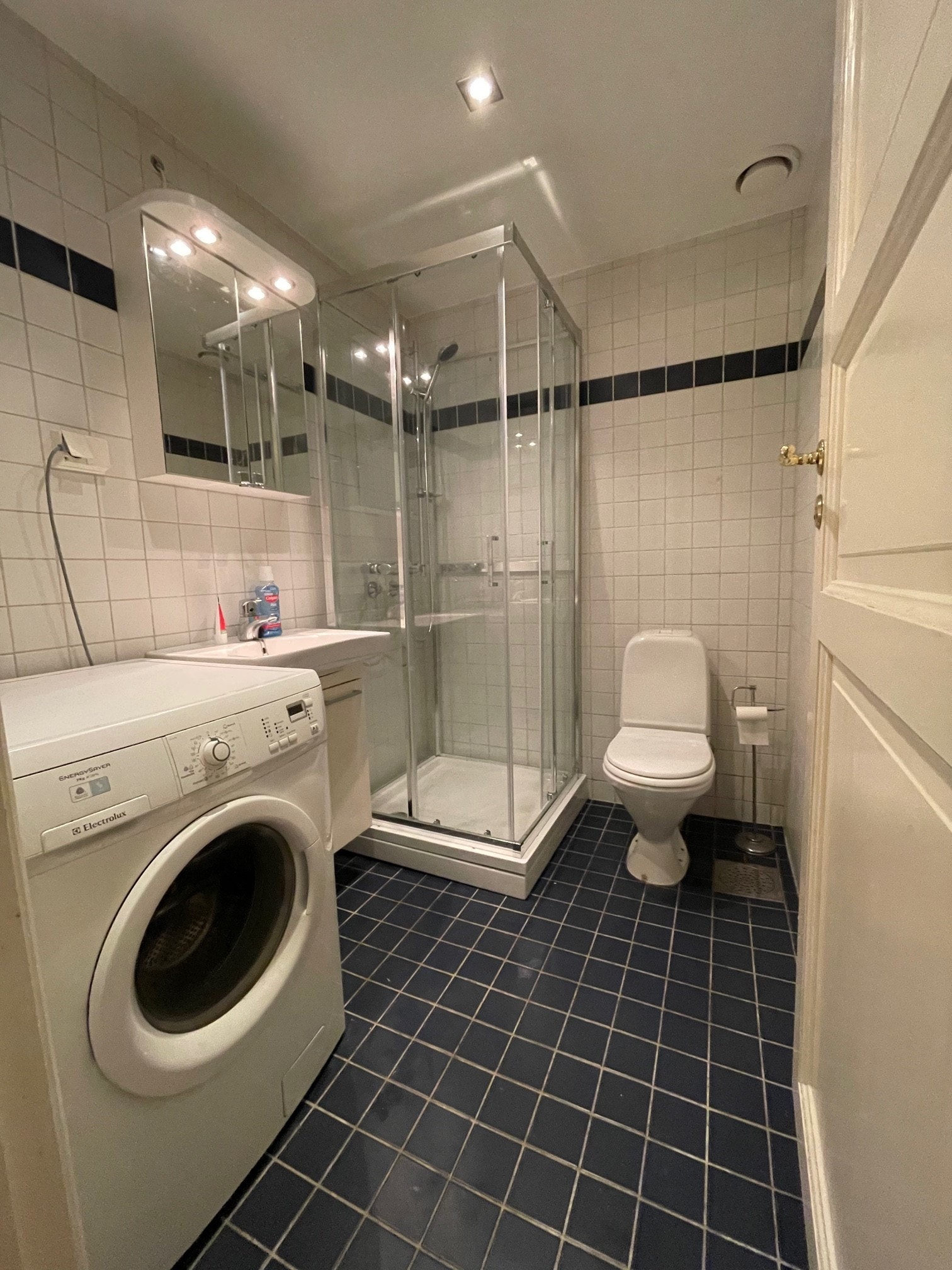 Flislagt bad med varmekabler, det er plass til vaskemaskin og tørketrommel. Galleribilde