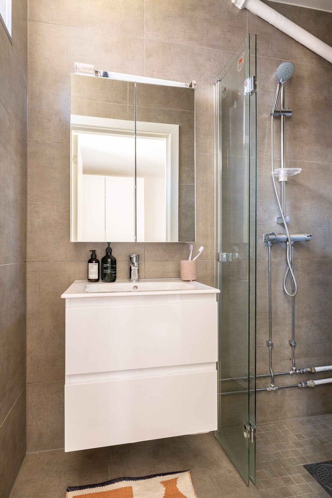 Badet oppleves romslig og lyst, med tidløse fliser på vegger og gulv. Galleribilde