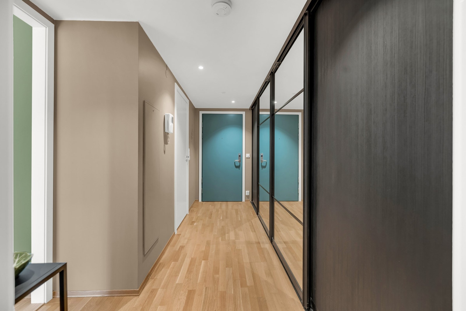 Langs den ene veggen er det montert en heldekkende, plassbygget skyvedørsgarderobe med speilfronter som gir gode muligheter for oppbevaring. Galleribilde