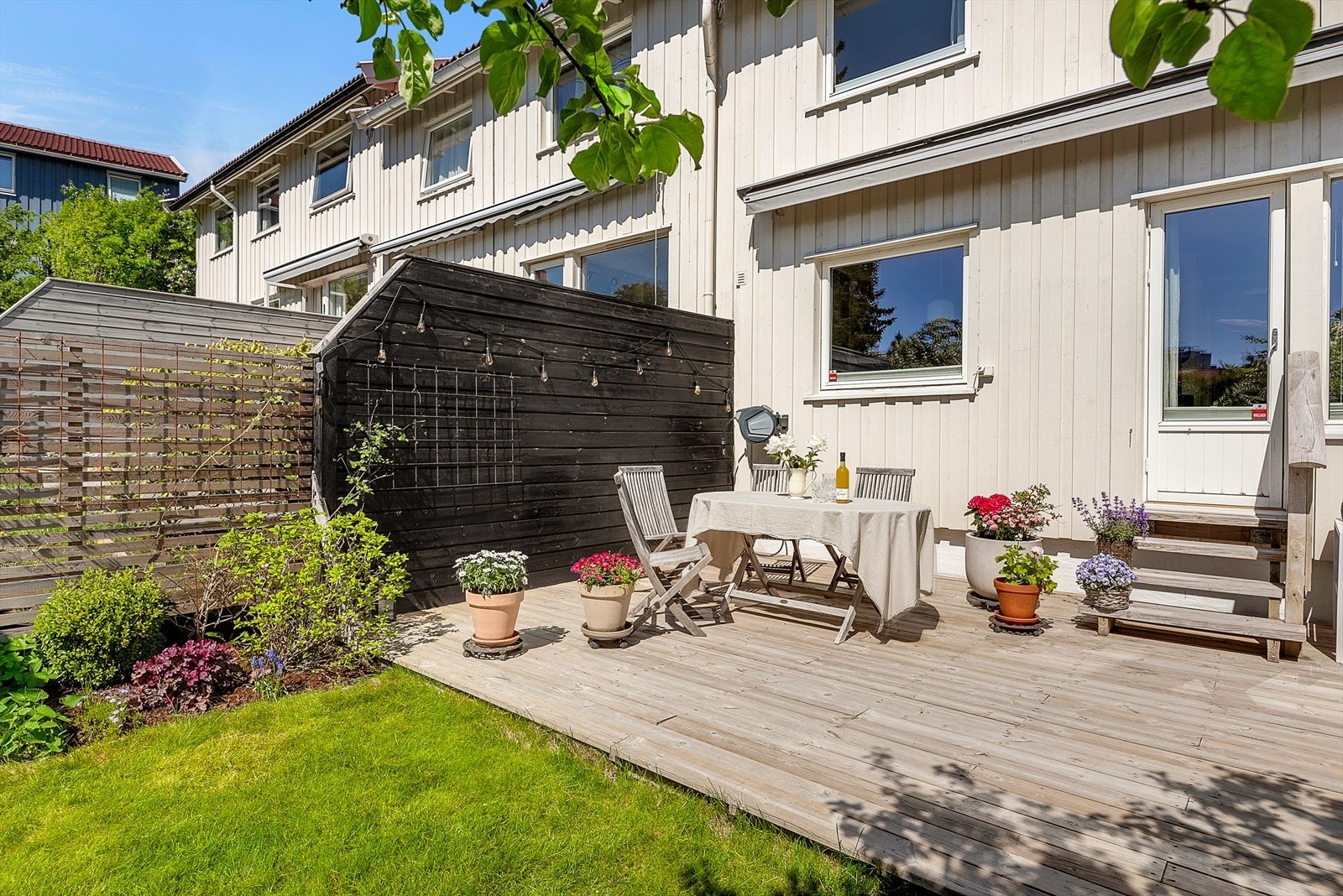Hagen har gressplen og er pent beplantet. Galleribilde