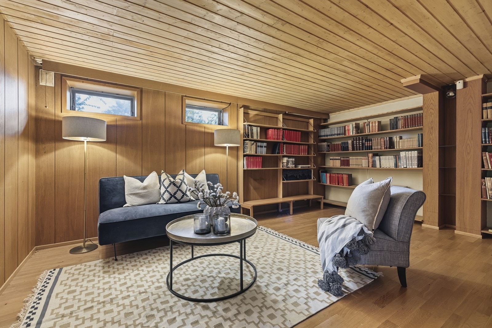 TV-stue/kjellerstue med parkett på gulv og panel på vegger og i himling. Galleribilde