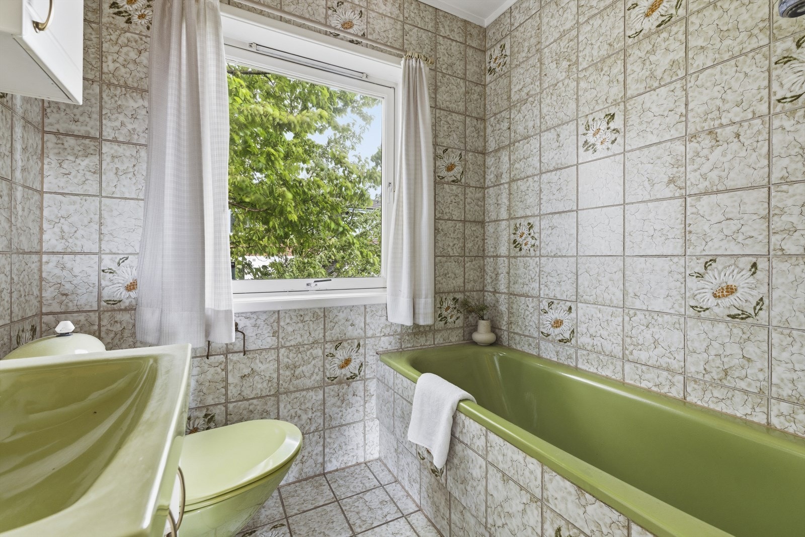 Badet i første etasje har flislagte overflater, innbygget badekar og varmekabler i gulvet. Galleribilde