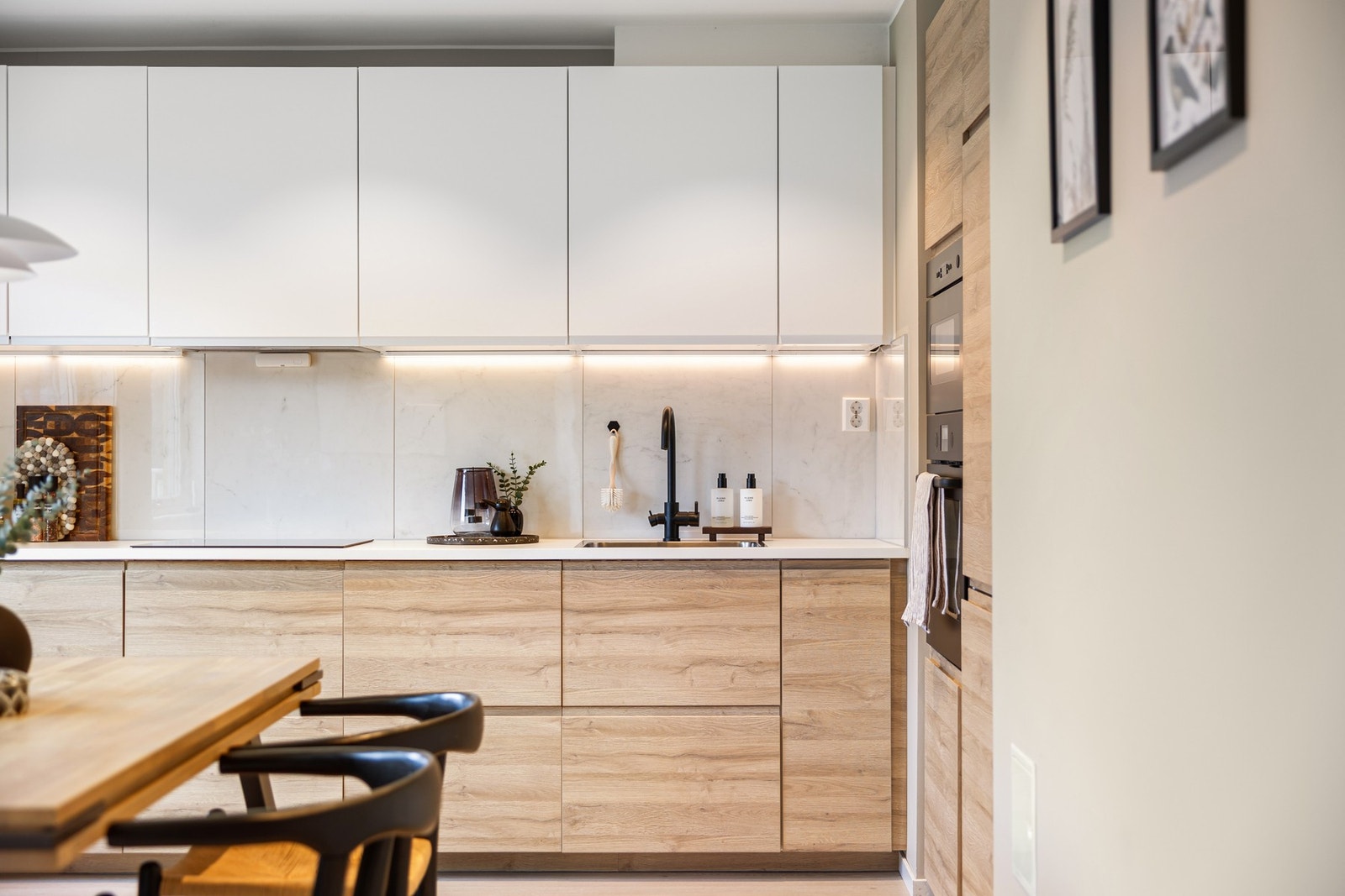 Laminert plate mellom benkeplate og overskap og malt nedsenket himling m/downlights. Galleribilde
