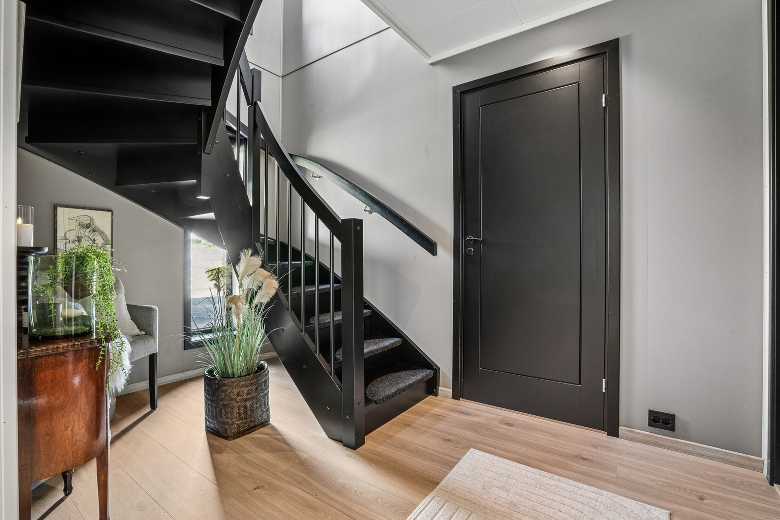 En lekker, sort trapp med moderne uttrykk setter et stilfullt preg på gangen. Boligen har en smart og funksjonell planløsning med bad og soverom i 1. etasje. Galleribilde