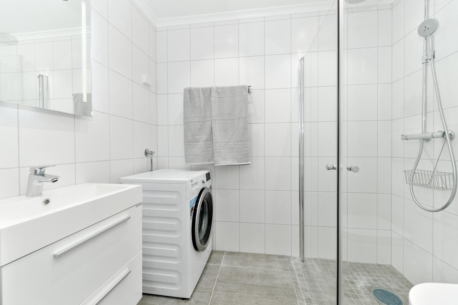 Flislagt bad med wc, dusjhjørne, servant og vaskemaskin Galleribilde