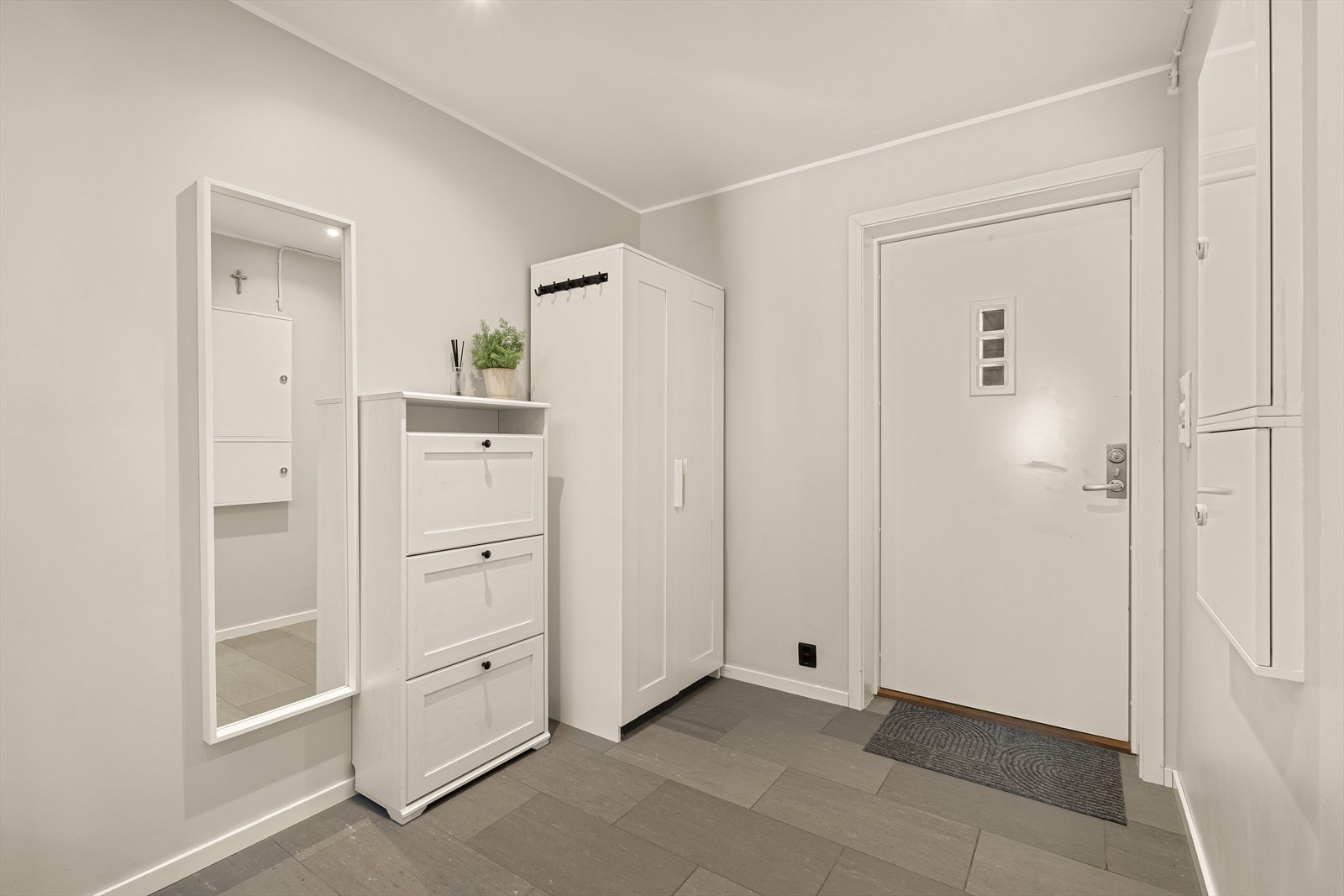 Entréen er romslig og innbydende. Her er det god plass til garderobeløsning og kommode for oppbevaring av yttertøy og sko. Galleribilde