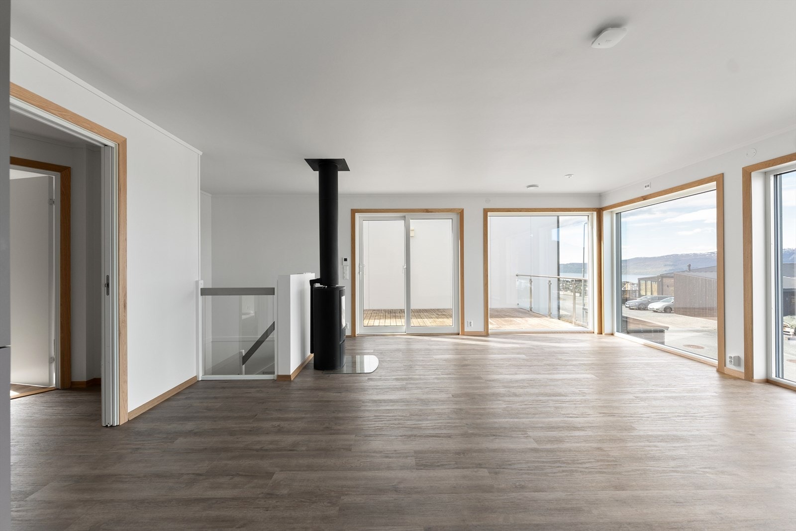 Velkommen inn til en lys og innbydende stue- og kjøkkenløsning med store vindusflater som slipper inn rikelig med dagslys, flott utsikt og vedovn som skaper en lun og hyggelig atmosfære. Galleribilde