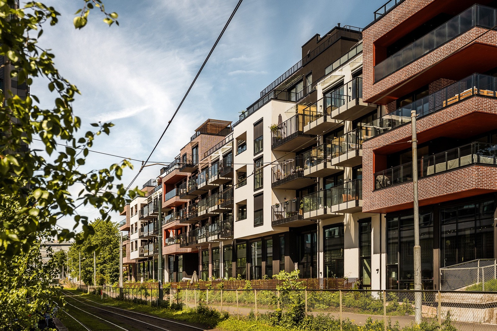 Bygget fra 2025 har en moderne fasade med teglstein og pussede flater. Thune trikkestopp er kun to minutter unna. Galleribilde