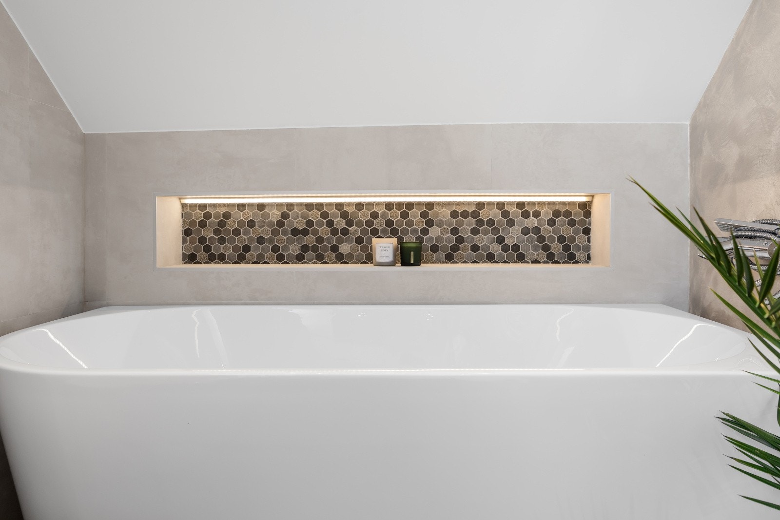 Badet har et frittstående badekar som tilfører rommet et stilrent og eksklusivt preg. Galleribilde