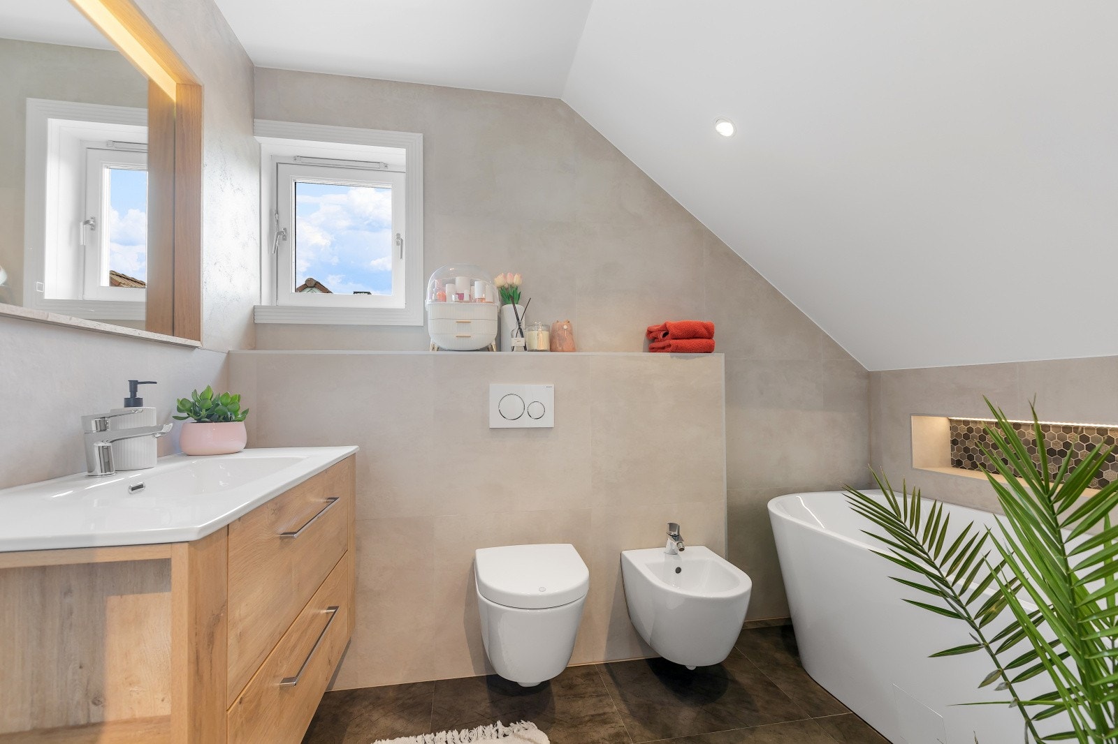 Badet i 2. etasje er innredet med vegghengt toalett, badekar, bidé samt servant med speil og integrert belysning. Galleribilde