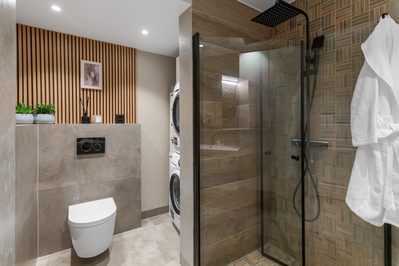 Badet er totalrenovert og utvidet, og fremstår som et romslig og moderne kombinert bad og vaskerom. Galleribilde