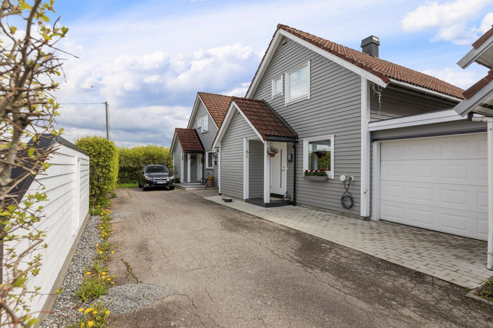 Eiendommen har asfaltert innkjørsel samt parkering i garasje med elektrisk port. Det er også installert elbillader på husveggen for enkel og praktisk lading. Galleribilde
