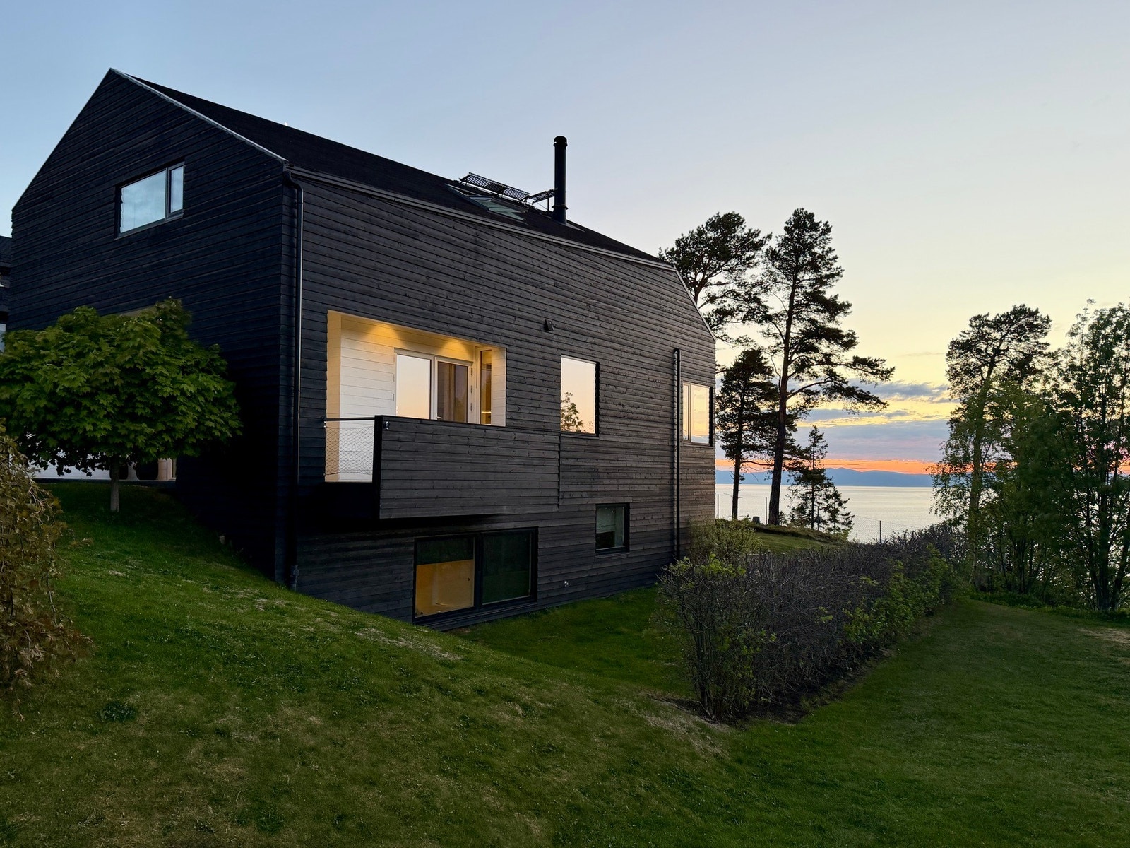 Et hus som rommer mer enn det man kan se eller anta fra utsiden - huset har slikt sett et minimalistisk og rent uttrykk utvendig, men innehar "alt" en familie kan ønske seg. Galleribilde