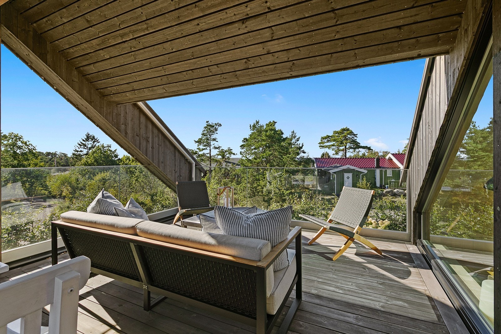 Delvis overbygget takterrasse på ca. 24 m² med moderne rekkverk i glass og metall. Galleribilde