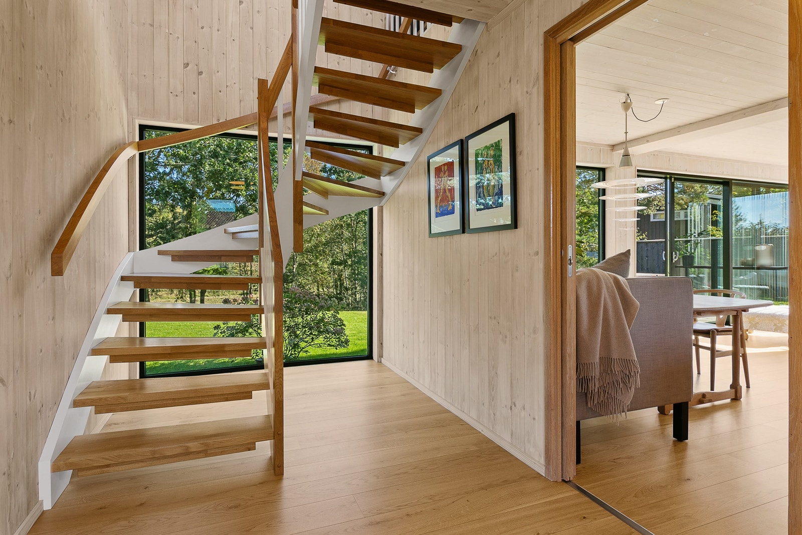 En lekker tretrapp med eiketrinn leder opp til en lys og romslig loftsstue. Galleribilde