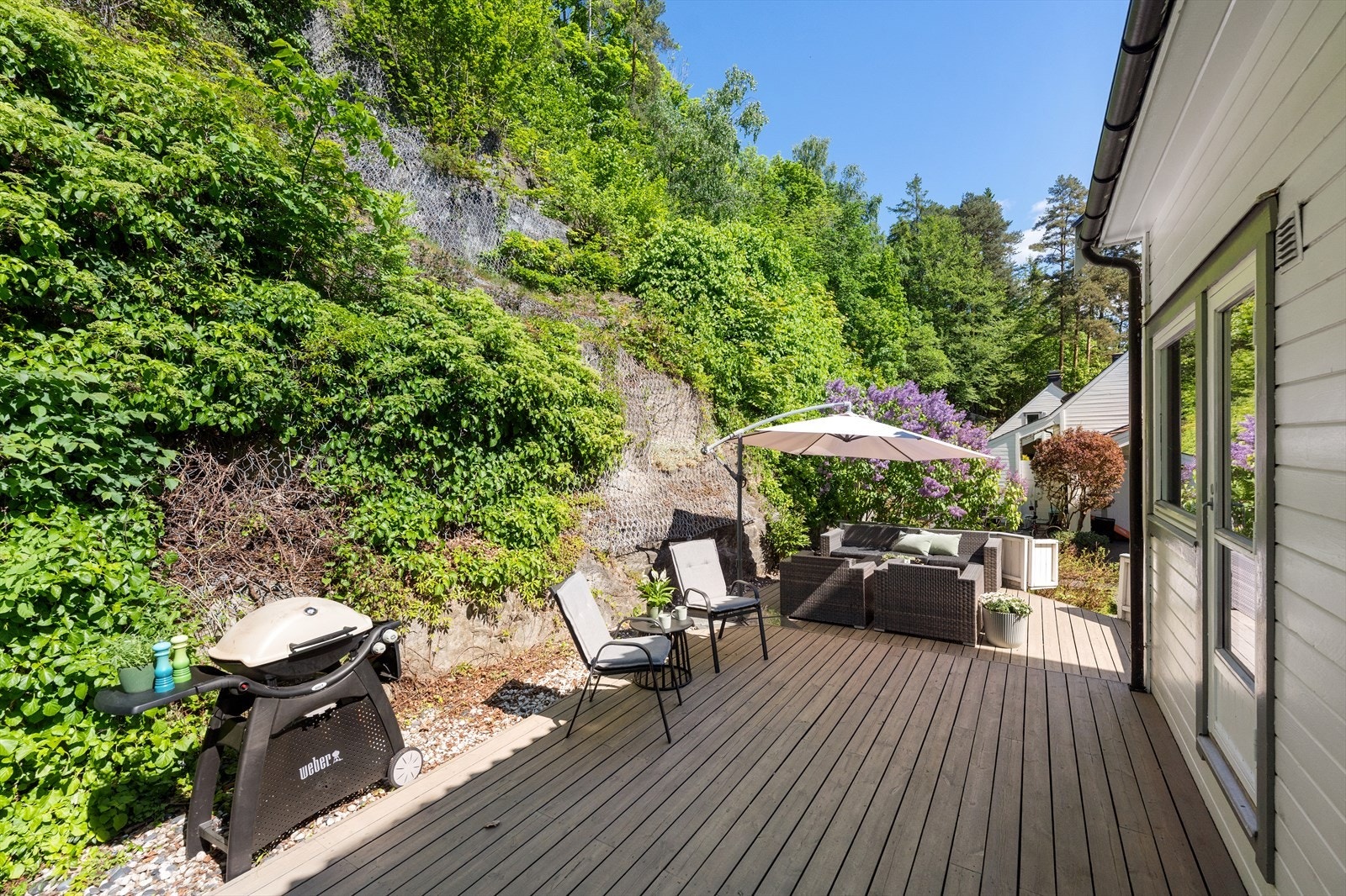Fra spisestuen er det utgang til en romslig, nordvestvendt platting på ca. 46 kvm i impregnert trevirke. Her er det god plass til både loungegruppe, noen gode stoler og grill - perfekt for hyggelige sommerdager og sosiale sammenkomster. Galleribilde