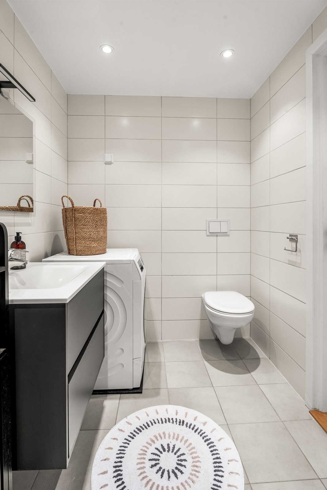 Badet er innredet med vegghengt toalett, servant nedfelt i baderomsinnredning samt dusjhjørne med forheng. Det er opplegg for vaskemaskin. Galleribilde