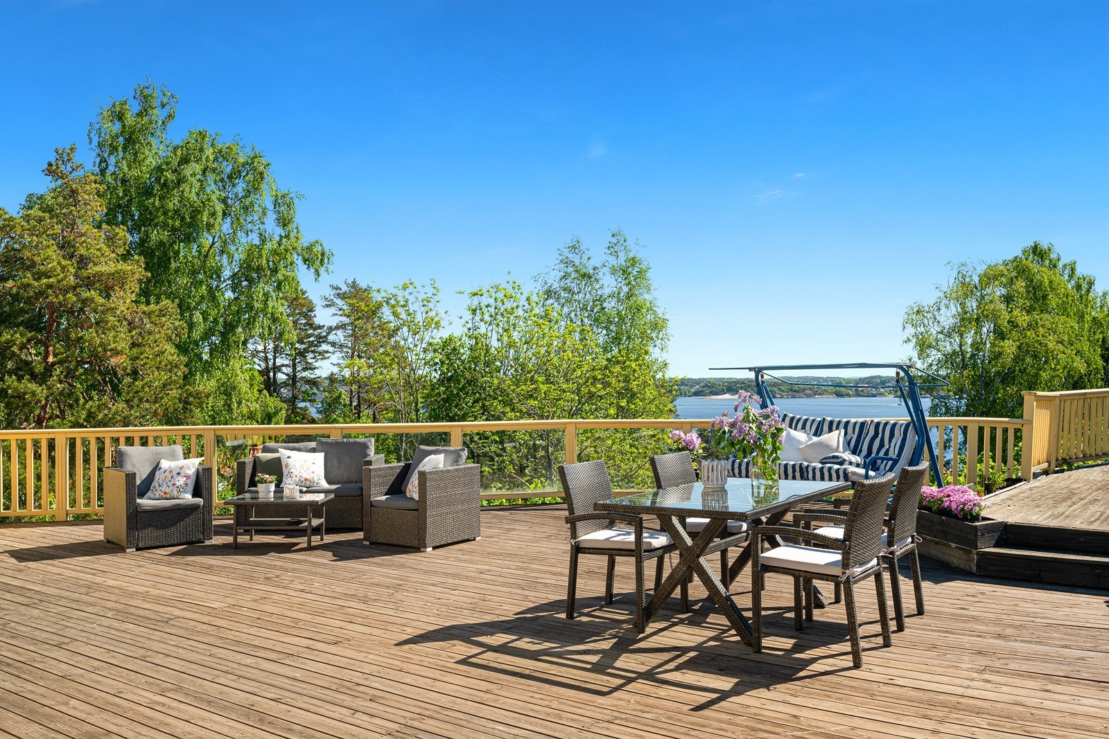 Terrassen har god plass til både sittegruppe og spisebord. I bakgrunn skimtes også Hvittensand på andre siden av fjorden. Galleribilde