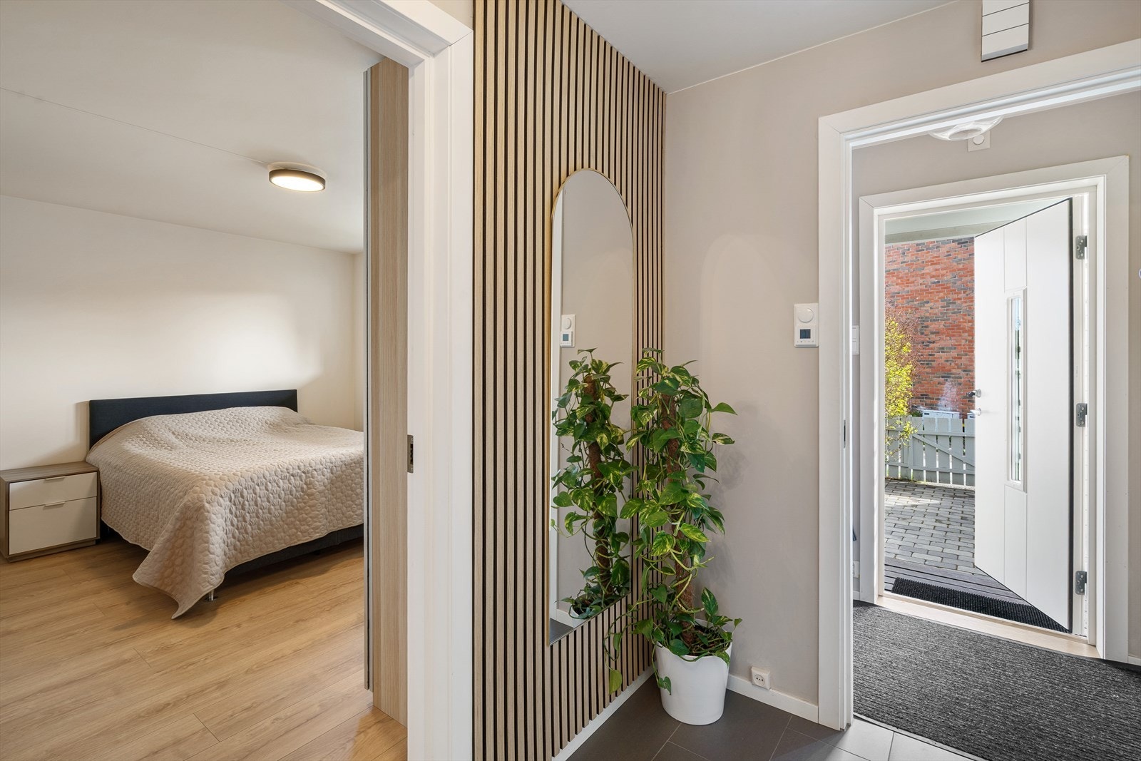 Entréen har flislagt gulv med varmekabler. En vegg med spiler gir et moderne preg. Galleribilde