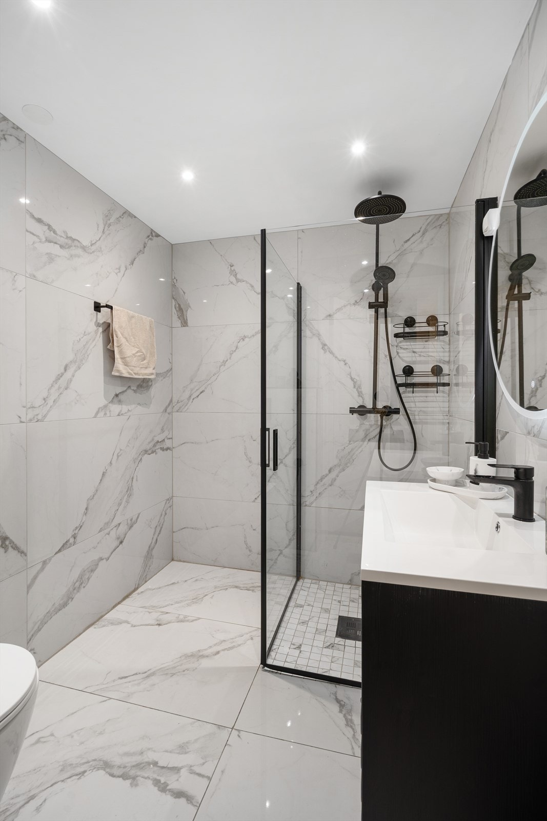 Badet i første etasje er fra 2025, med fliser på gulv og vegger, samt varmekabler. Galleribilde