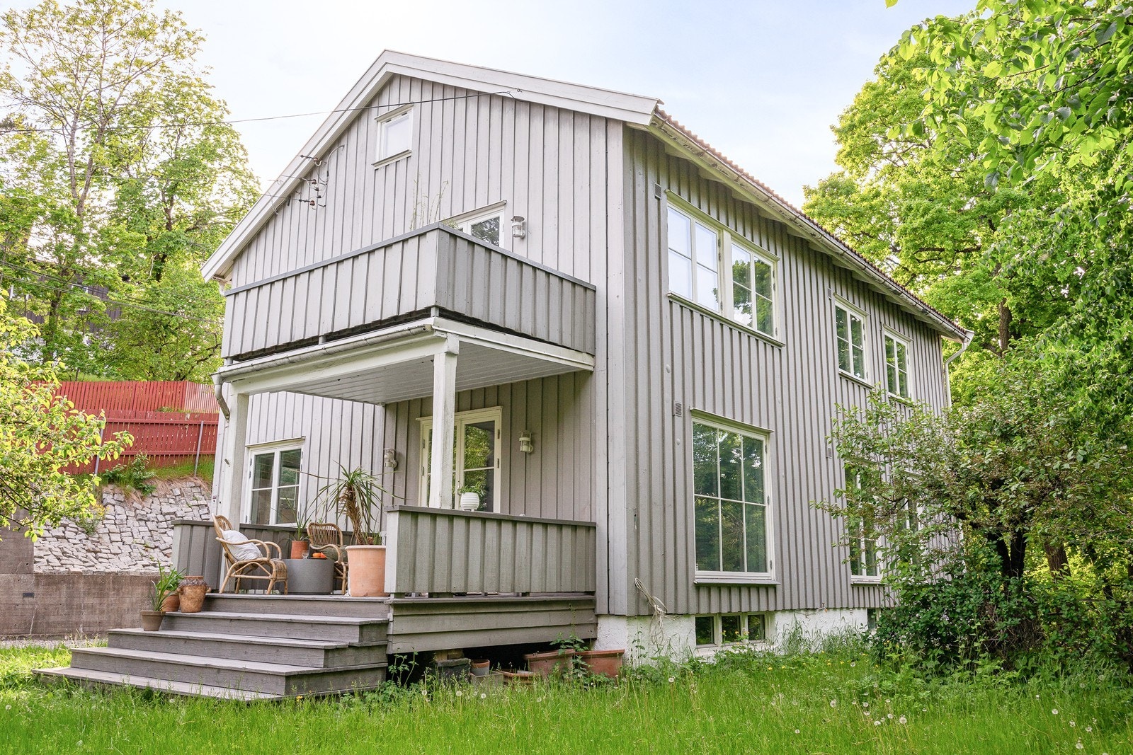 Enebolig med fasade i stående bordkledning og tak tekket med betongtakstein. Galleribilde