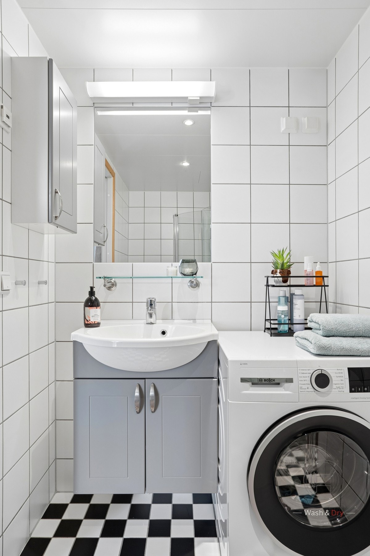 Badet er en prefabrikert kabin med flislagte overflater, servantinnredning og opplegg for vaskemaskin. Galleribilde
