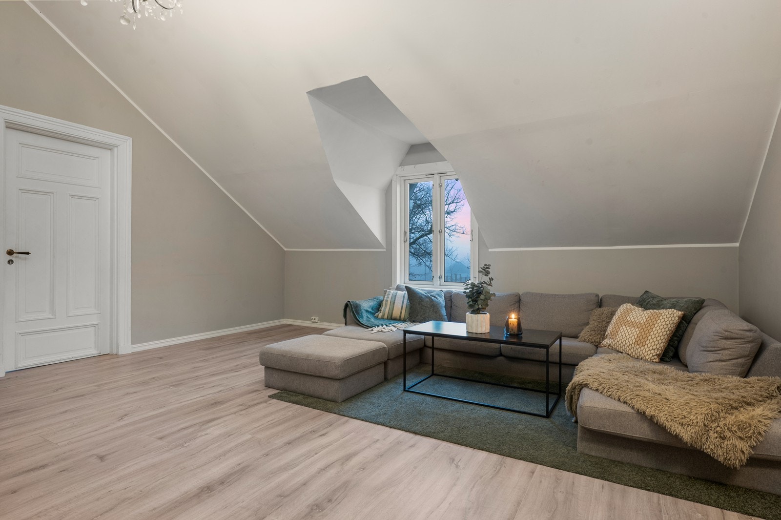Laminatgulvet og slettmalte vegger gir en moderne finish til stuen. Galleribilde