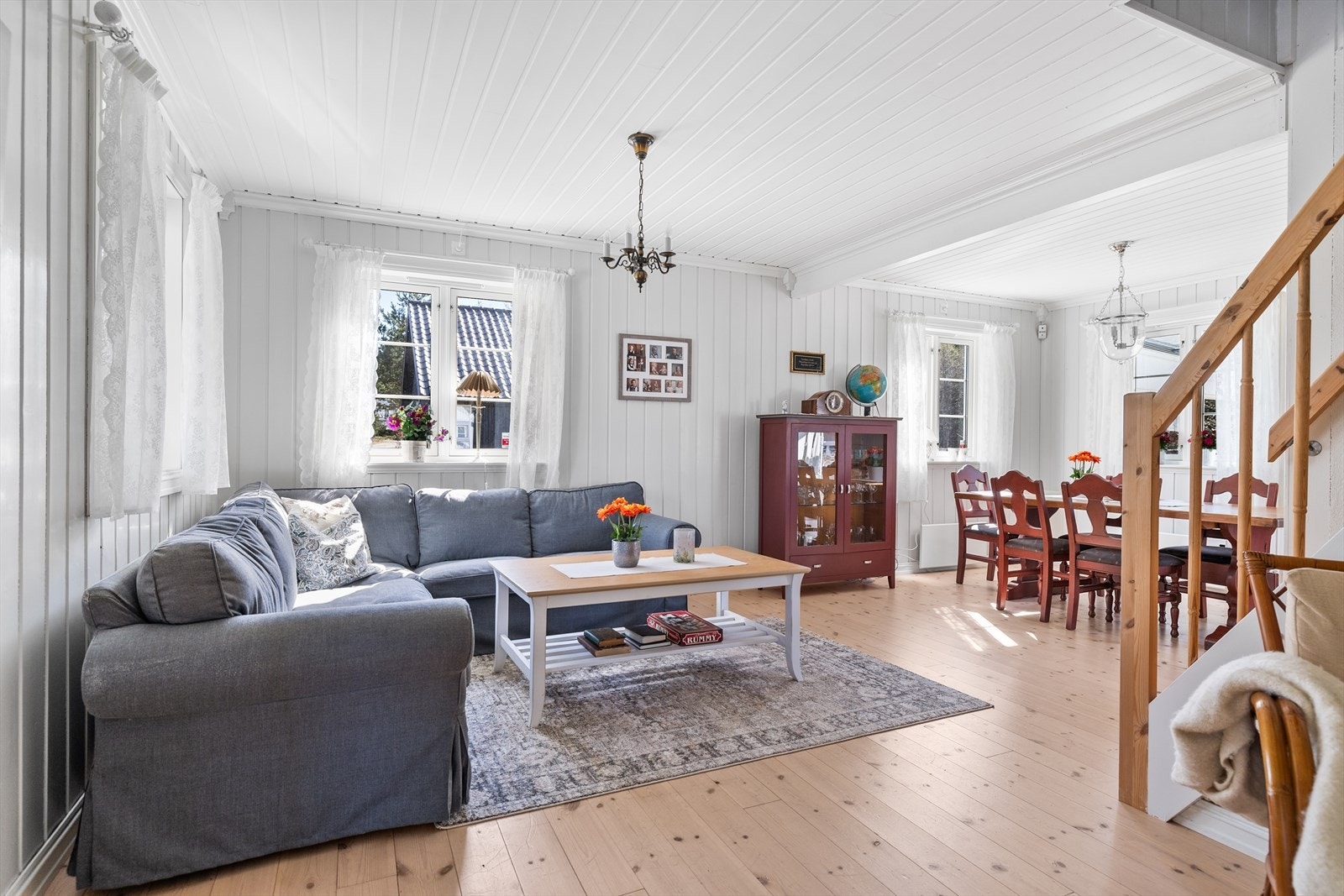 En lys og luftig stue i åpen løsning med spisestuen, som skaper en sosial og romslig atmosfære. Galleribilde