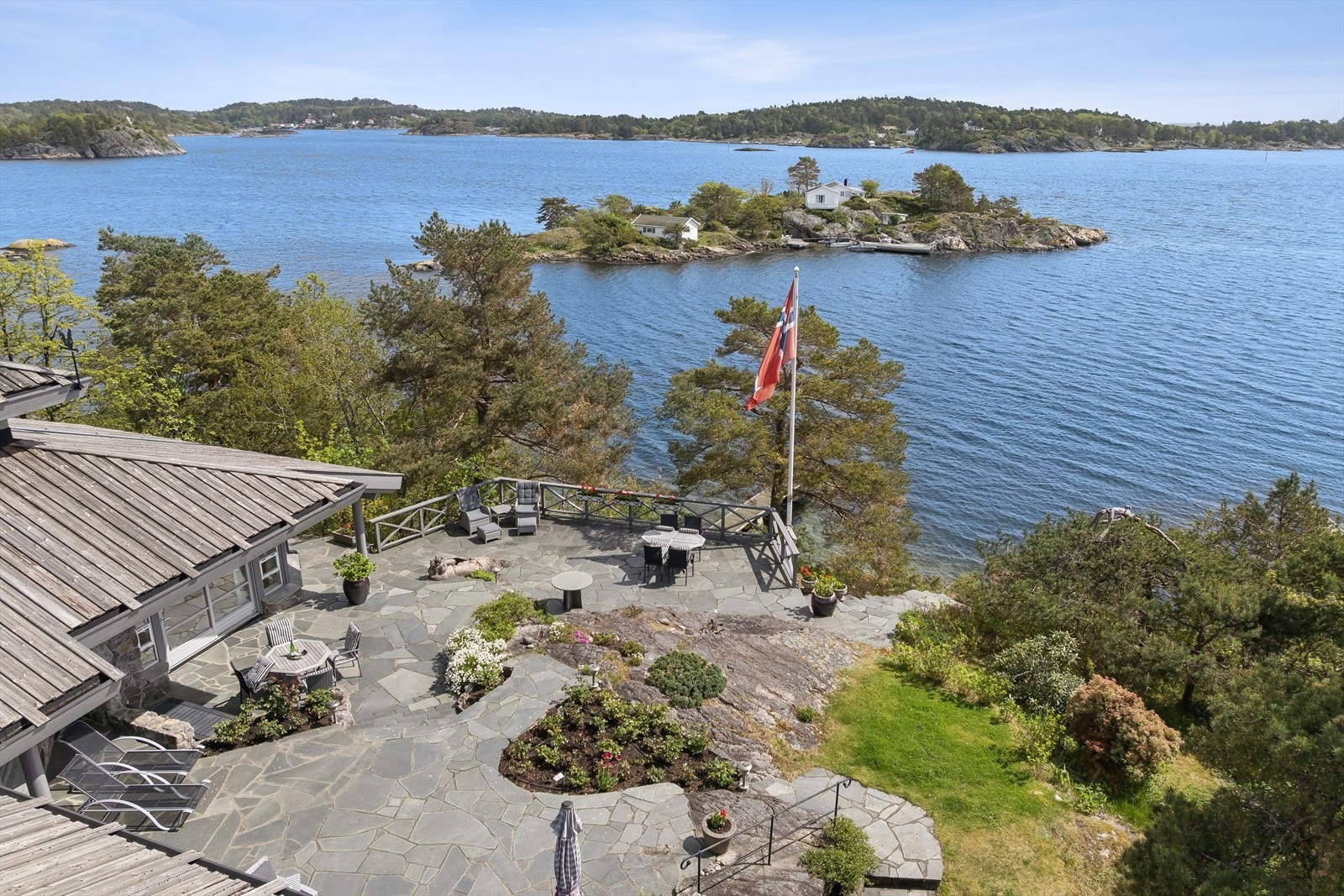 Eiendommen ligger tilbaketrukket i et meget attraktivt og rolig boligområde på Groos, og har lang strandlinje m/ egen brygge og strand! Galleribilde