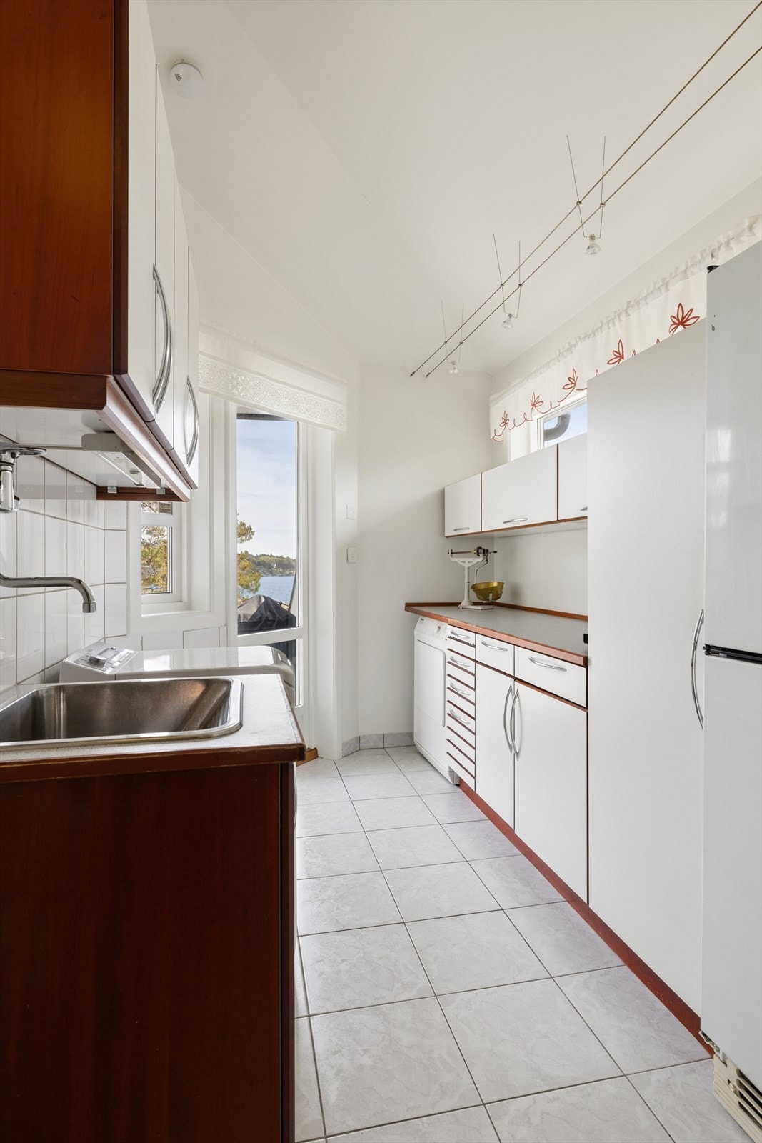 Praktisk vaskerom i 1. etasje med flislagt gulv, opplegg for vaskemaskin og egen kum. Innredningen er fra HTH og UNOFORM. Direkte utgang. Galleribilde