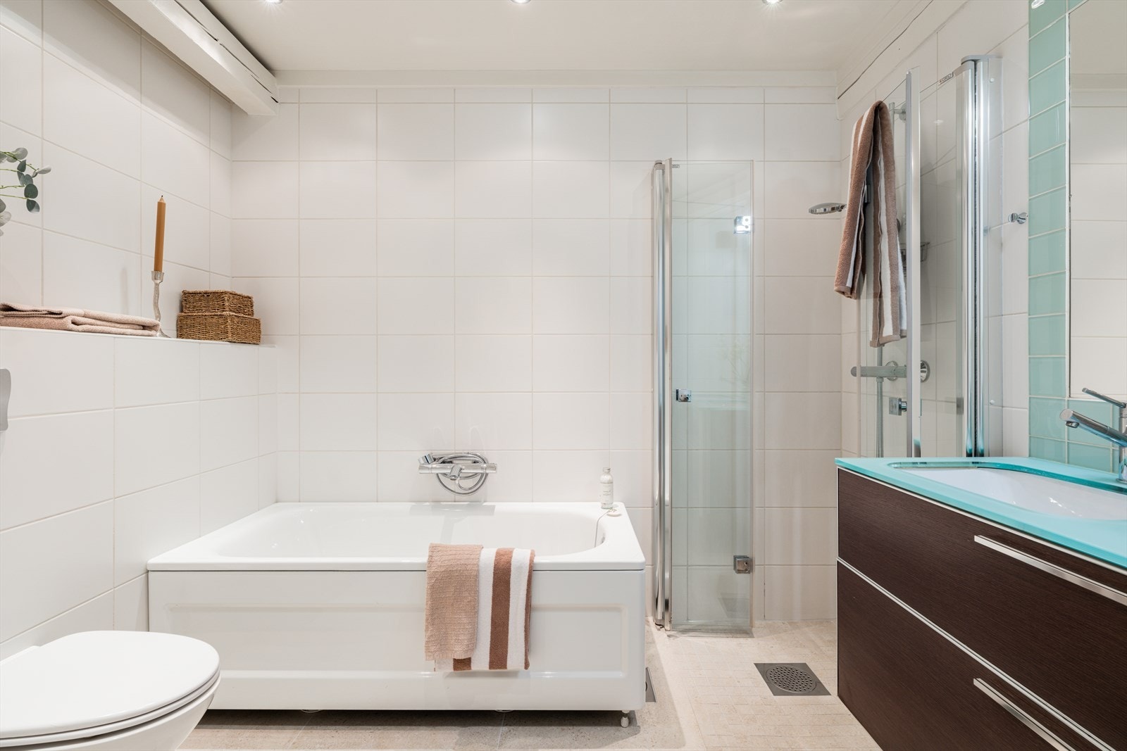 Badet er innredet med både badekar og egen dusjnisje med doble glassdører. I 2026 ble gulvflisene oppgradert med nye, moderne fliser som bidrar til et tidsriktig og elegant uttrykk. Galleribilde