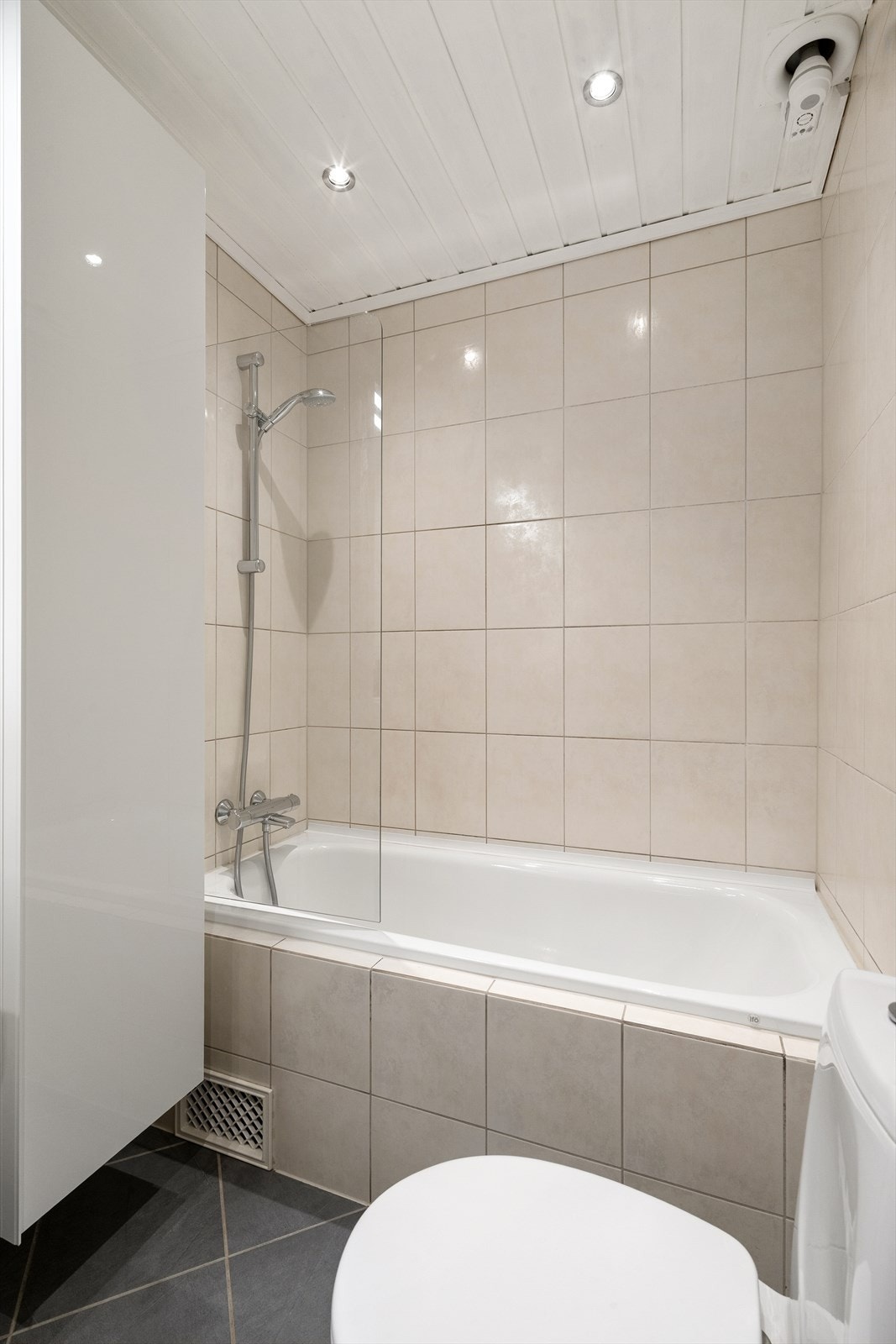 Badet er flislagt og utstyrt med badekar og elektriske varmekabler i gulvet. Galleribilde