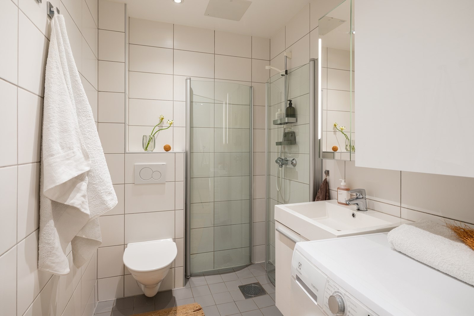 Badet er av god størrelse med plass til det man trenger på et bad. Her har man en romslig dusj, vegghengt toalett, servant og opplegg til vaskemaskin. Baderommet er fra 2014. Galleribilde