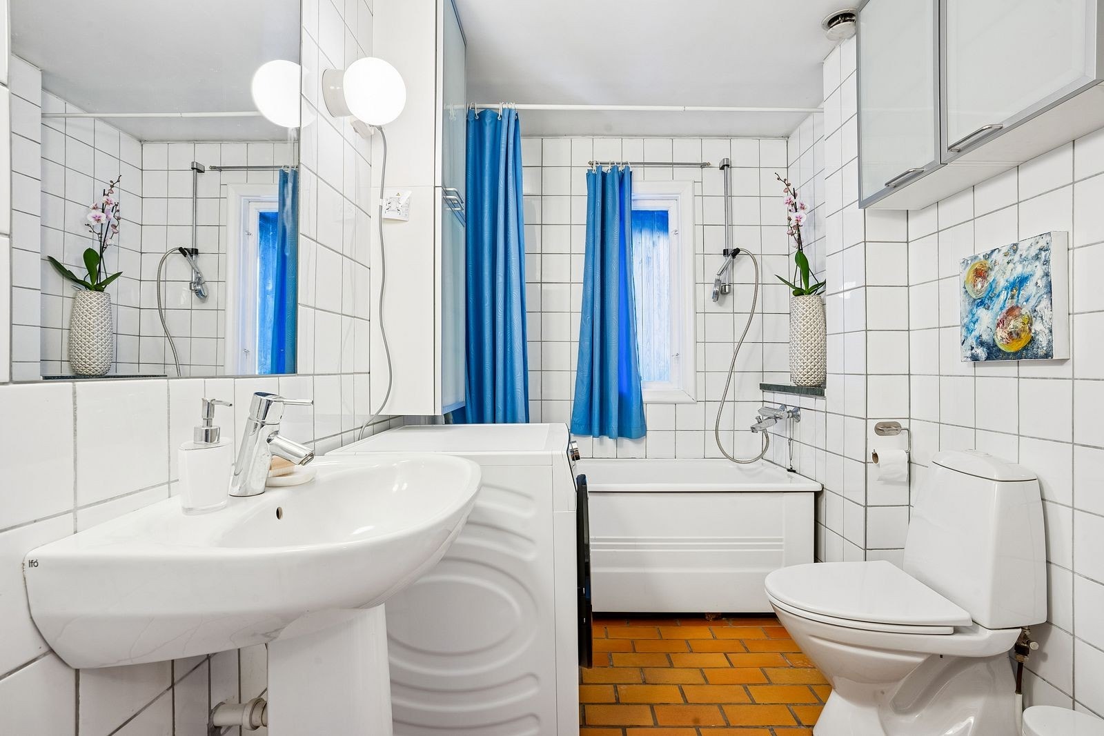 Lyst og flislagt bad med vaskemaskin. Galleribilde
