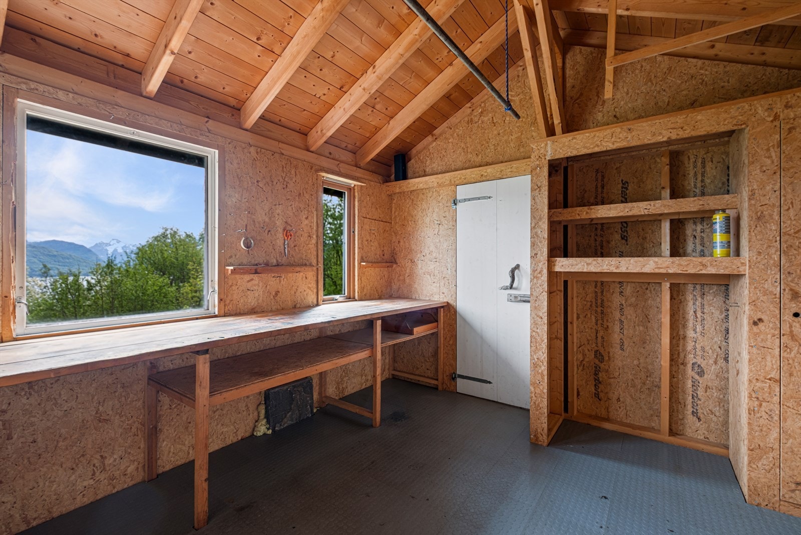 Uthuset har praktiske arbeidsbenker og naturlig ventilasjon via vinduer. Galleribilde