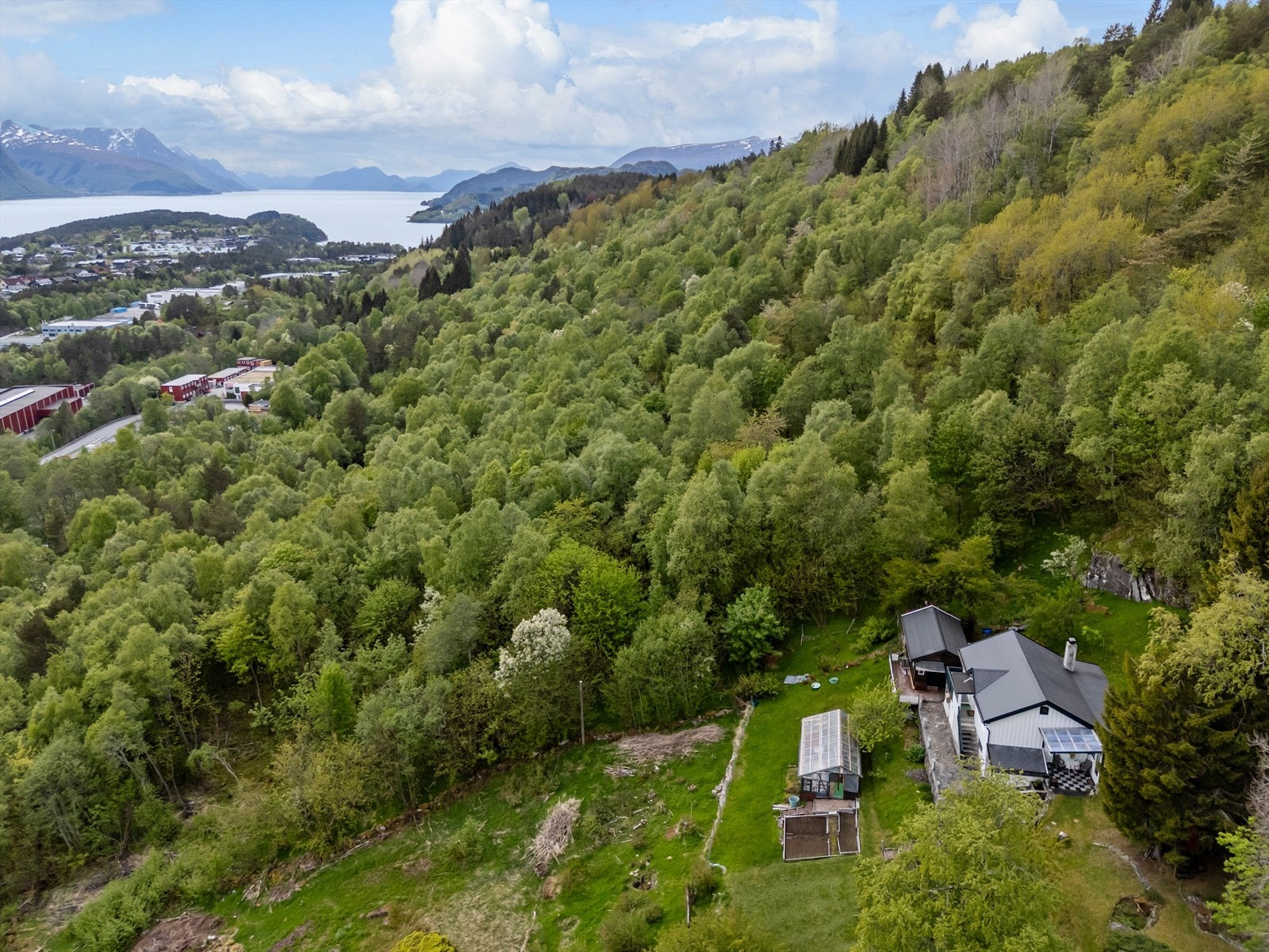 Eiendommen ligger landlig til med romslig tomt som inkluderer plenarealer, frukttrær og terrasserte nivåer. Galleribilde