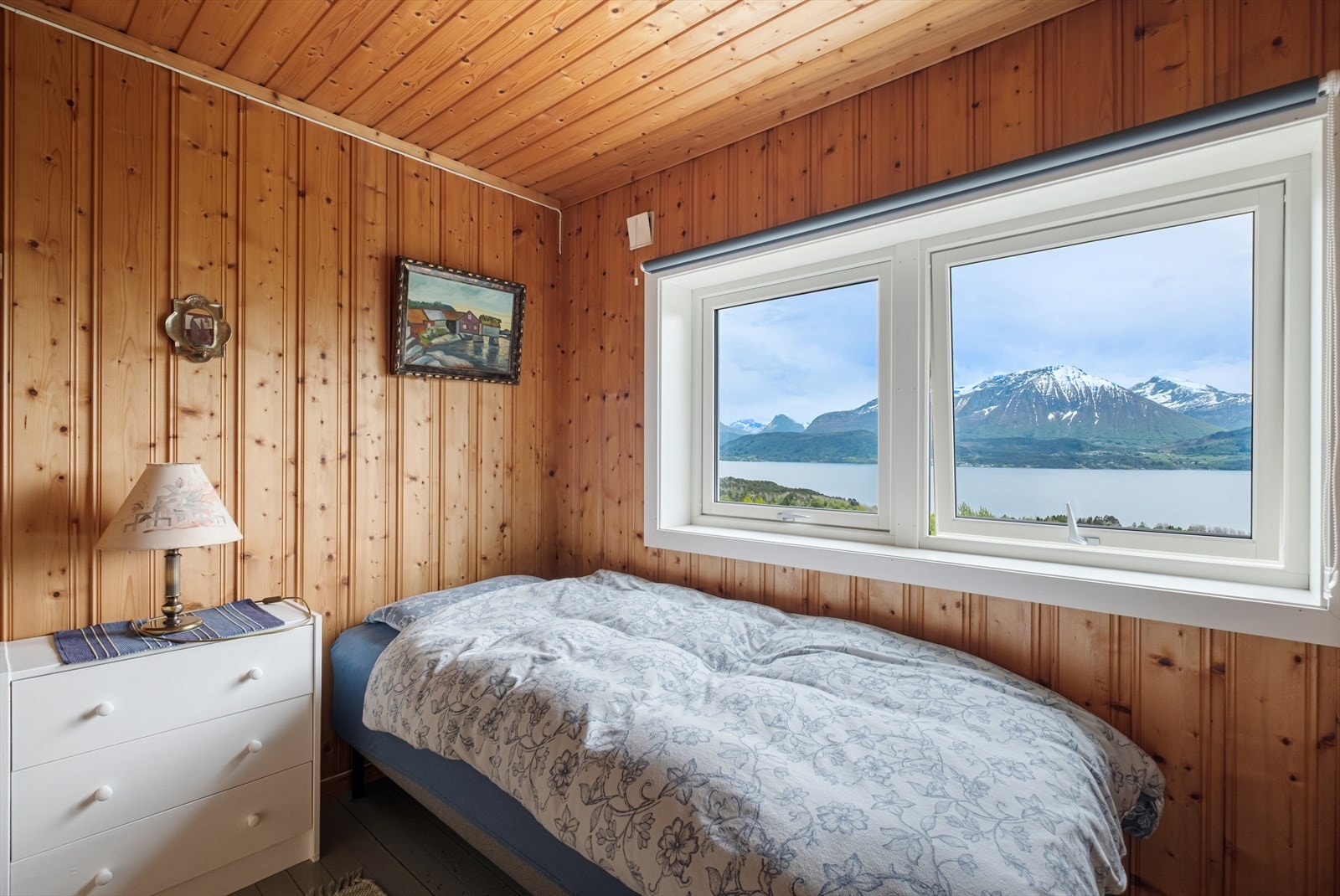 Store vindusflater gir utsikt mot fjord og fjell fra soverommet. Galleribilde