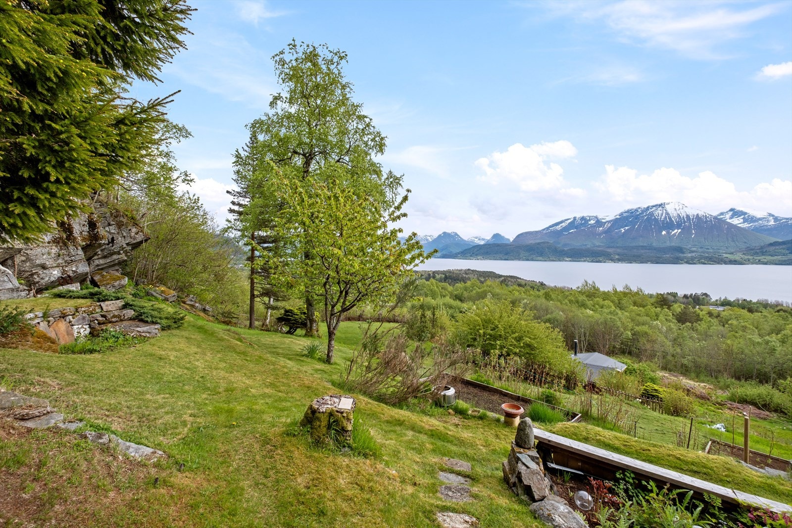 Tomten er opparbeidet med naturpregede partier, terrasserte nivåer og frukttrær. Galleribilde